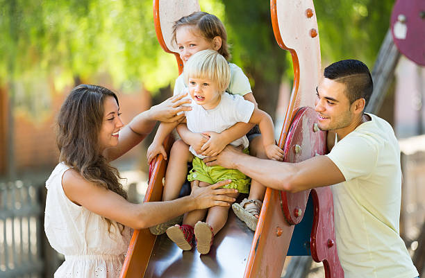 istock Family playing at children's slide 523291393