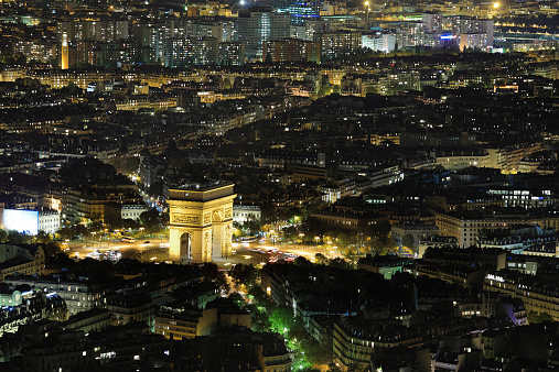 Aerial Night view of Arc de Triomphe and Paris City shot on the top of Eiffel Tower