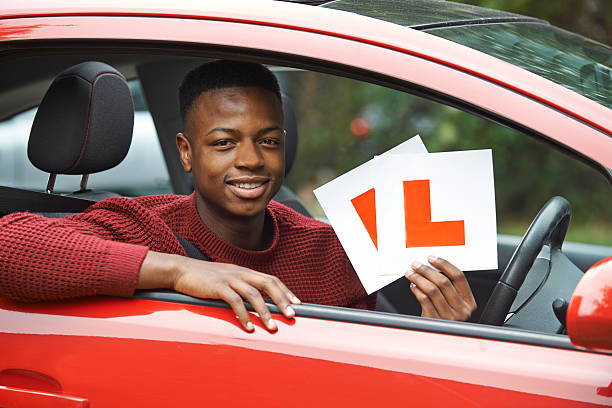 jeune garçon souriant en voiture après un examen de conduite - passing photos et images de collection