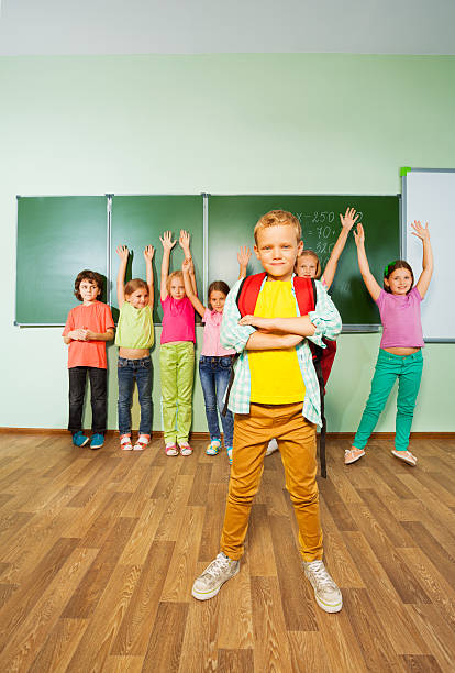 istock Boy stands in front of children with hands up 523312949