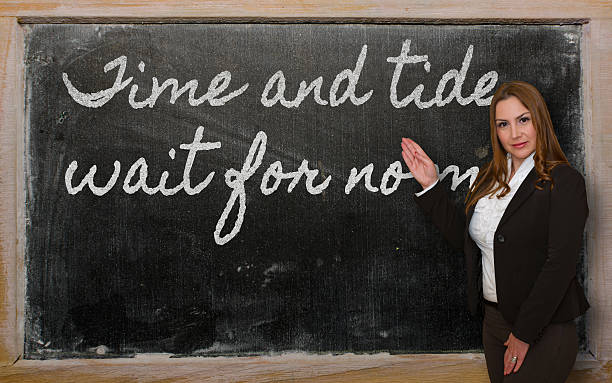 istock Teacher showing Time and tide wait for no man 523317159