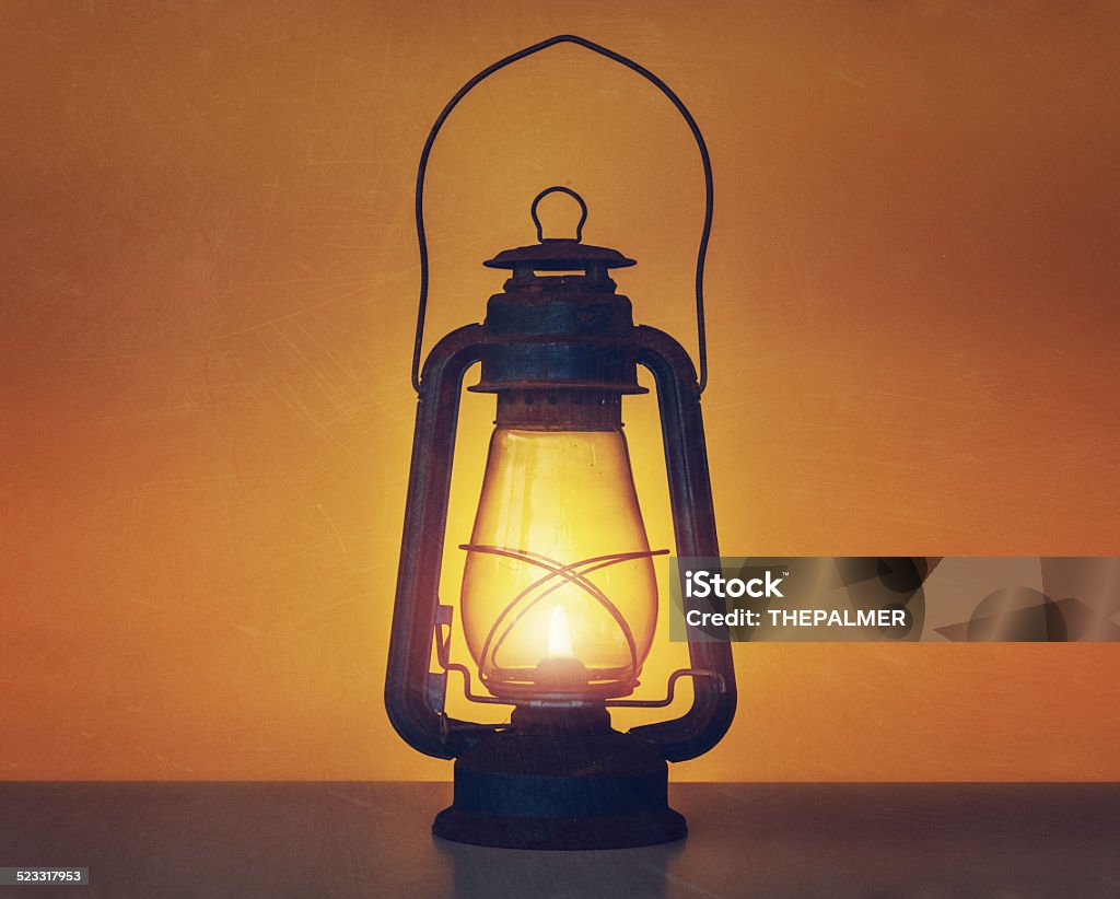 Old kerosene lamp Old and scratched kerosene lamp on a board glowing Lantern Stock Photo