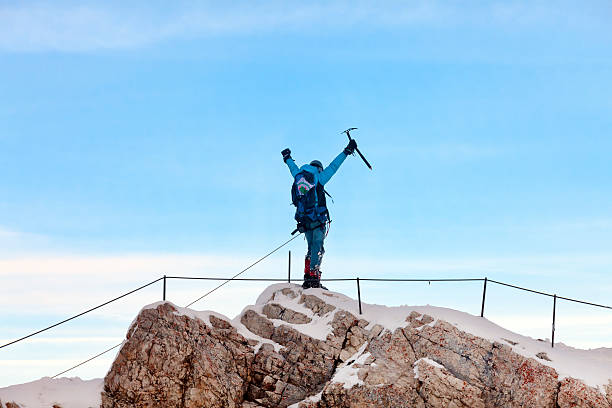 Garmisch Partenkirchen, Germany - November 9, 2014: Polish mountain climber raising hands after reaching summit of Zugspitze (2962 m, (9,718 ft) in Eastern Alps, the highest mountain in Germany as well as the highest peak of the Wetterstein Mountains, on the border between Austria and Germany.