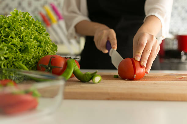istock Woman Cutting Tomatoes 523318631