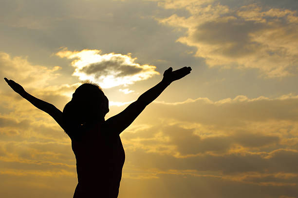 istock cheering woman open arms to sunrise at seaside 523355191