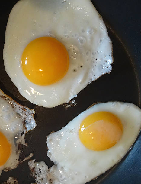 istock Three fried eggs being cooked in non-stick frying pan, breakfast 523359217