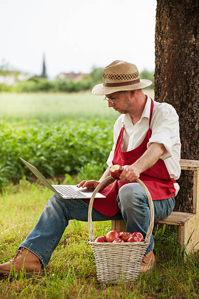 istock senior gardener in his orchard browsing on notebook computer 523359591
