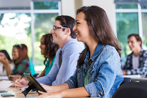 istock Female teenager smiling in class with digital tablet. 523360171