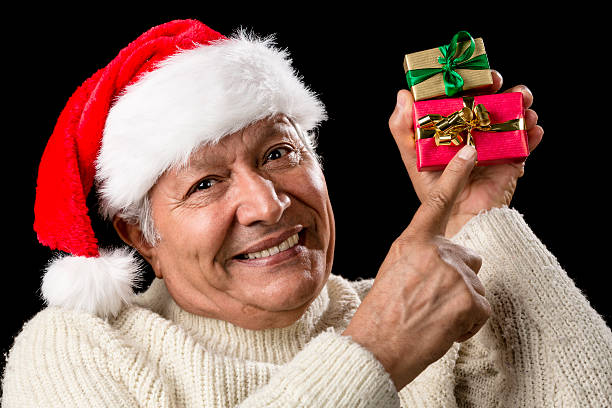 istock Smiling Senior Pointing At Two Wrapped Xmas Gifts 523360703