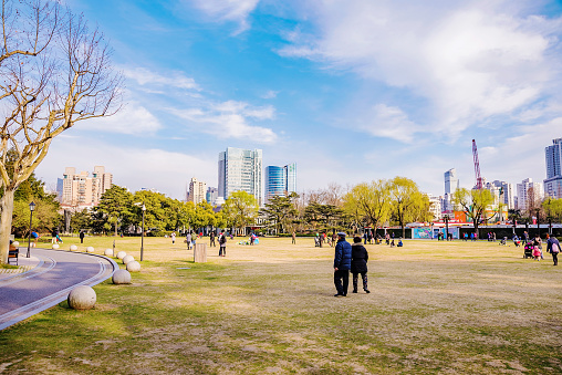 Shanghai, Сhina - March 15, 2016: Zhongshan park with Chinese people playing and walking on a sunny day.