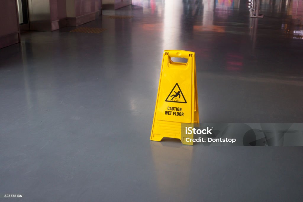Wet Floor Sign Elevated view of yellow warning sign on floor. Caution Wet Floor Stock Photo