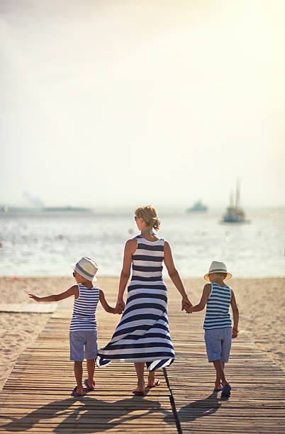 istock Mother with sons walking to the beach 523376160