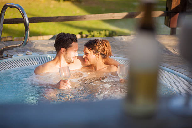 casal, desfrutando de uma banheira de hidromassagem - couple hot tub spa treatment health spa - fotografias e filmes do acervo