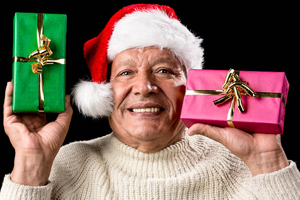 istock Kind Aged Gentleman With Red Cap Raising Two Gifts 523378421
