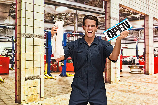 istock Excited mechanic holding open sign 523378990