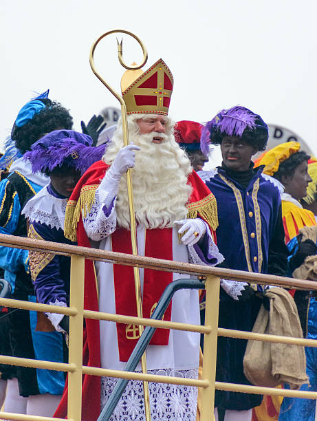 Sinterklaas and Zwarte Pieten on the Steamboat Kampen, The Netherlands - November 15, 2014: Sinterklaas and his black petes arriving on his steamboat in the city of Kampen, The Netherlands. Sinterklaas and his black helpers are waving to the children who are waiting for the old bishop to arrive. zwarte piet stock pictures, royalty-free photos & images