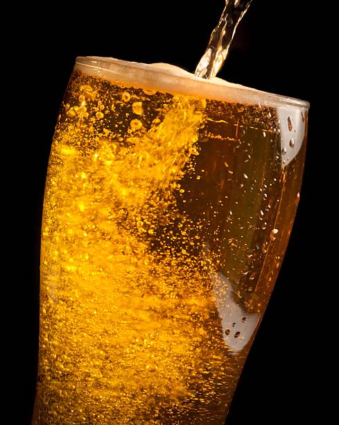 istock fresh beer pouring from bottle into glass 523381920