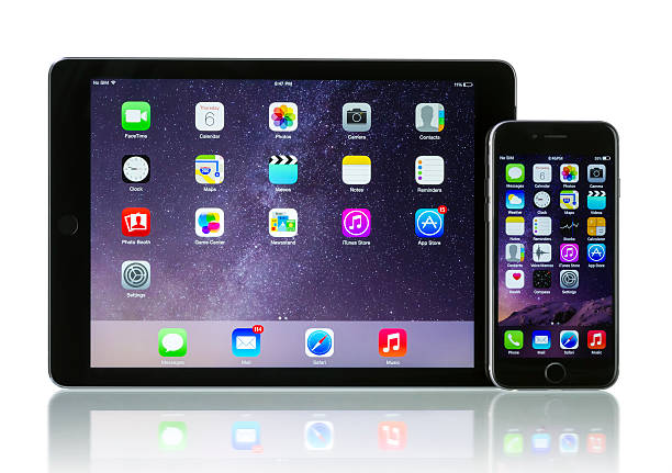 Koszalin, Poland - November 05, 2012: Top view of white iPhone 5 and iPad mini lying on snow. Devices display home screen. Close-up shot on iPhone 5. The iPhone 5 is smartphone with multi touch screen.The iPad mini is a smaller and thinner version of the iPad. It has a 7.9\