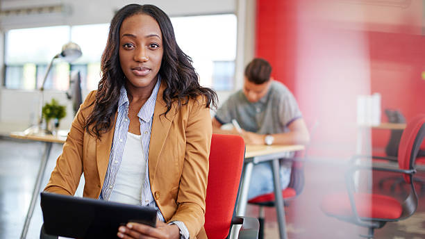Confident female designer working on a digital tablet in red