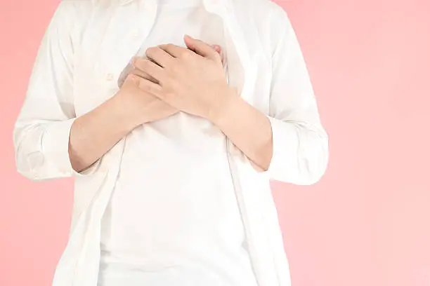 Photo of Asian man holding his heart