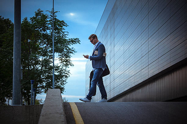 istock Young casual businessman using smartphone in the urban environment 523385314