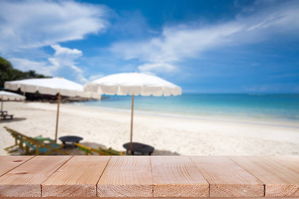 istock Wood table top on blurred blue sea and sand beach 523389640