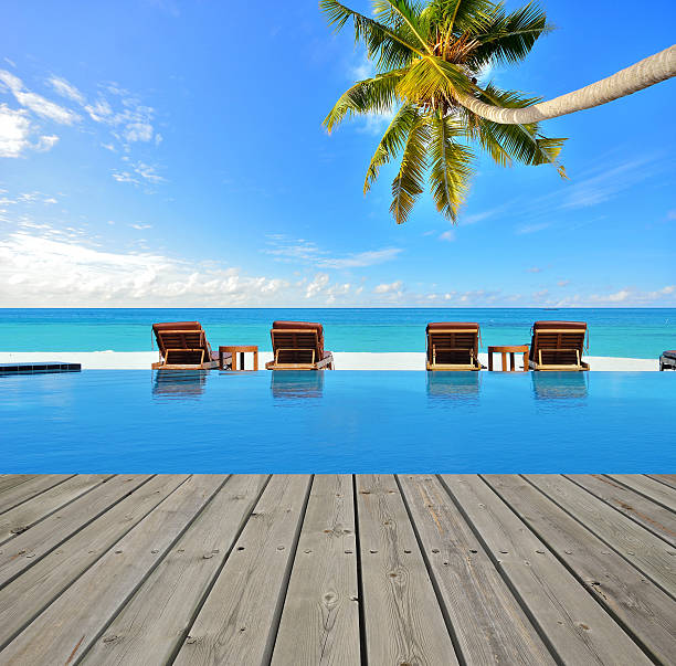 istock Wooden platform beside blue pool in tropical beach 523390464