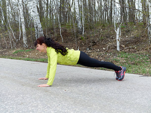 istock Young woman pushups outdoors in nature. 523391488