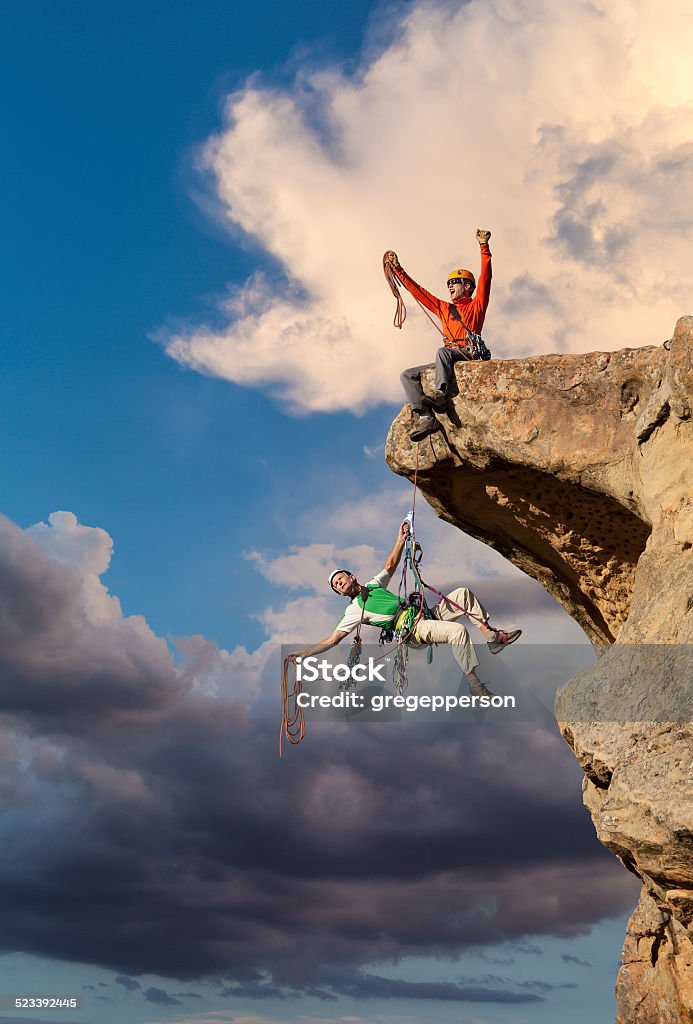 Success on a mountain peak. Climbing team taking the first step. Rock Climbing Stock Photo
