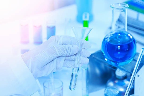 istock Flask in scientist hand with test tubes for analysis. 523392778
