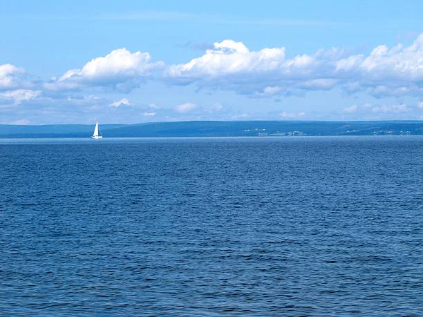 istock One Sailboat Against Blue Water, Hills and Sky 523393404