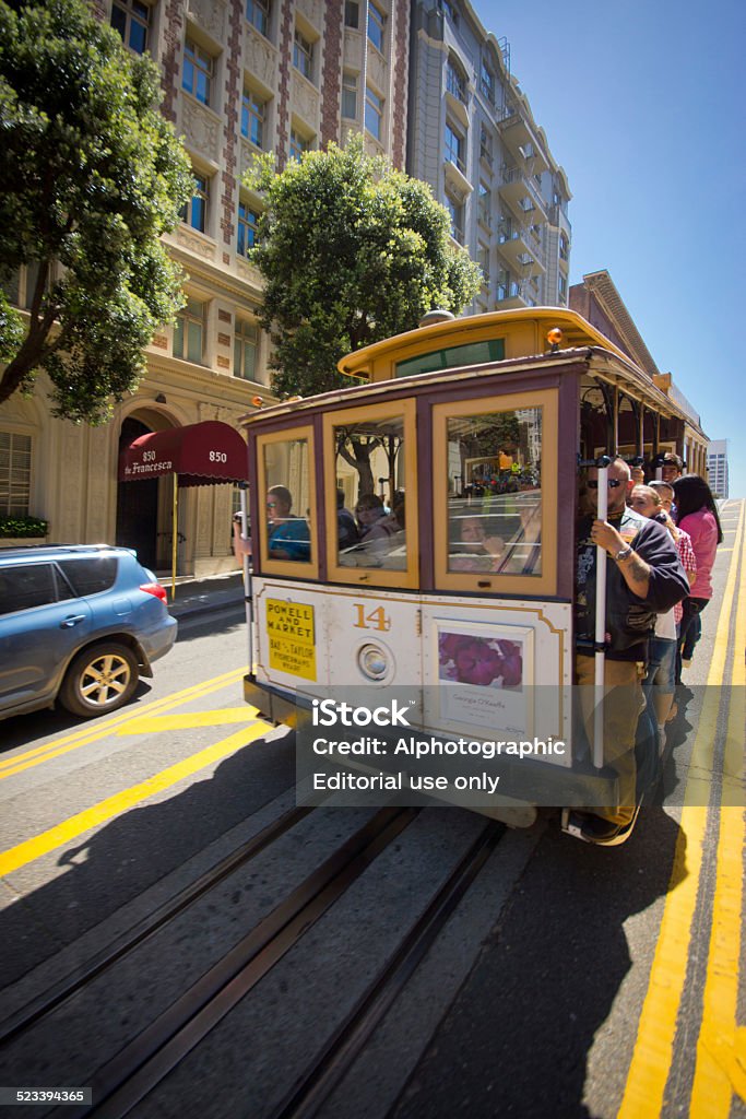 San Francisco cable car San Francisco, USA - April 14, 2014: San Francisco tram near Union Square with passengers hanging on to the side. Adult Stock Photo