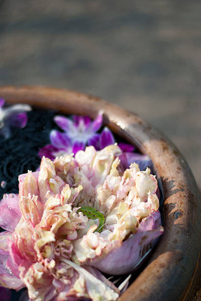 Stone bowl vase with water decorated with Hibiscus flowers arranged in circles on Maldivian island.