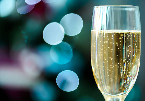 istock One champagne glass on christmas bokeh background 523398051