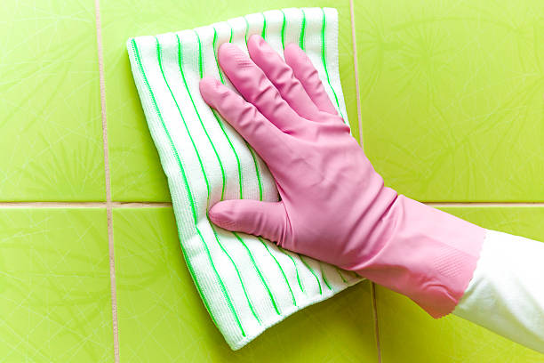 istock Pink protective glove cleaning tiles with rag. Early spring cleaning. 523399972