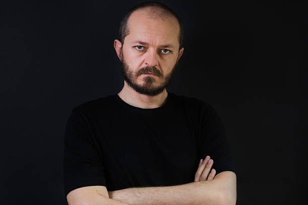 istock Man with beard and mustaches on black background, arms crossed 523400610
