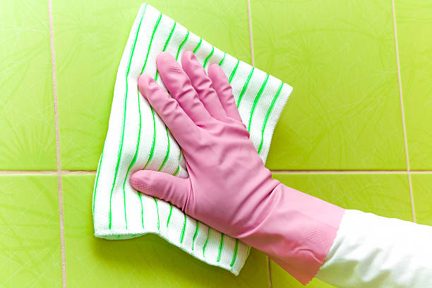 istock Pink protective glove cleaning tiles with rag. Early spring cleaning. 523402134