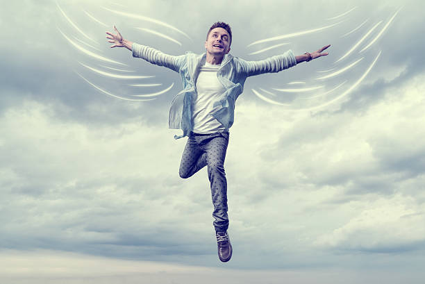 Young man with drawn wings flying in sky stock photo