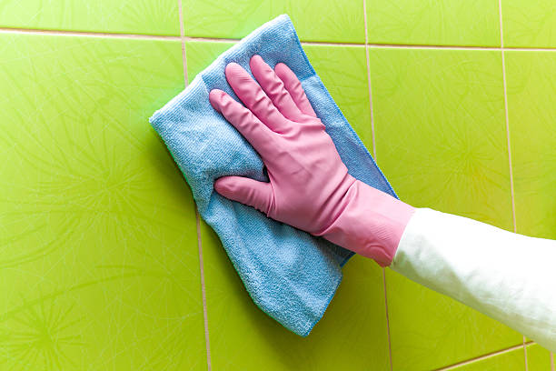 istock Pink protective glove cleaning tiles with rag. Early spring cleaning. 523402186