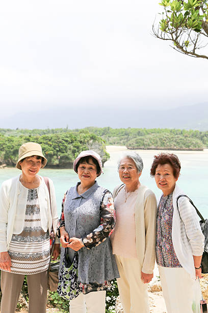 istock Elderly woman standing on the beach 523403570