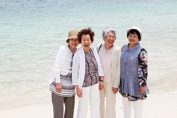 Elderly woman standing on the beach