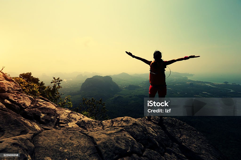 successful woman hiker enjoy the view on mountain top cliff Achievement Stock Photo