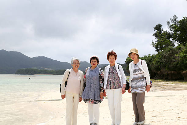 istock Elderly woman standing on the beach 523404136