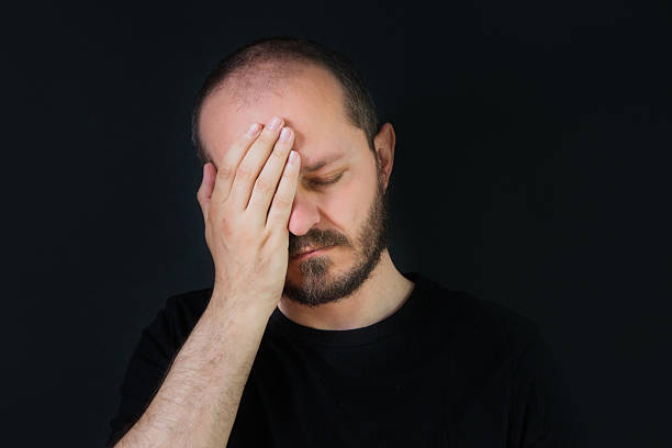 istock Man on black background, covering face with hand palm 523406814