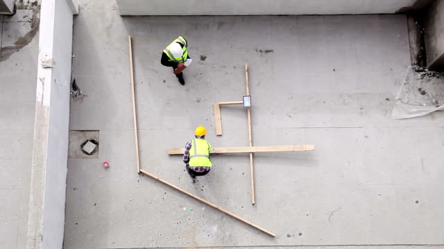 Overhead view of construction workers with wood planks at construction site