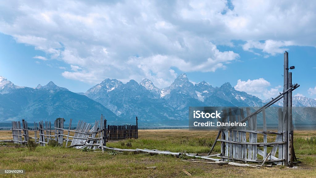 Grand Tetons mountains, Mormon Row,near Jackson, Wyoming, USA. Jackson, Wyoming, USA - Derelict fencing of  early Mormon homestead, Mormon Row, with Grand Tetons in the background near Jackson, Wyoming, USA. This shot was taken in late summer. American Culture Stock Photo