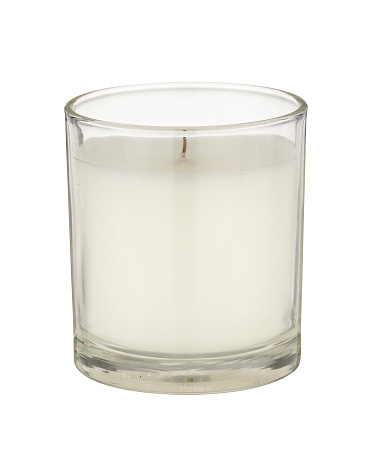 A white candle in a glass holder on a white background