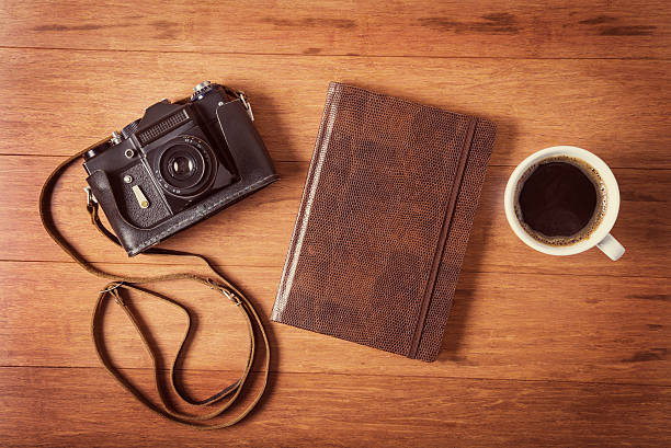istock Vintage camera, diary and cup pf coffee on wooden table. 523414805