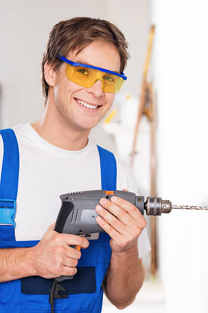 istock Smiling repairman with drill 523415243