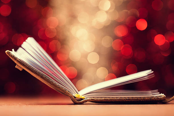 istock Open book against  defocused  lights abstract background 523417137